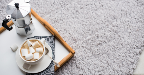 cocoa with a coffee pot on a tray lie on a gray carpet