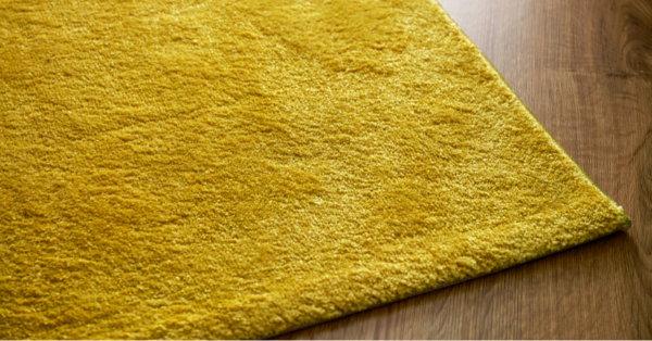 yellow rug on parquet